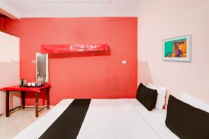 Camera rossa con letto e parete rossa di OYO Hotel Abhilasha a Bhilai