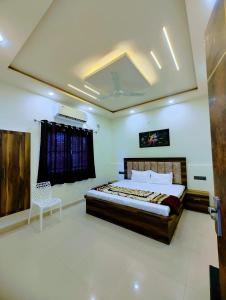 een slaapkamer met een bed en een stoel erin bij BRiJWAS DHAM in Vrindāvan