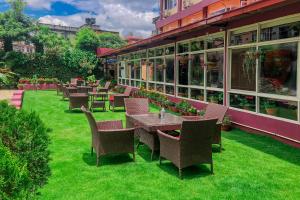 a row of tables and chairs on the grass in front of a building at Hotel Crown Plaza in Kathmandu