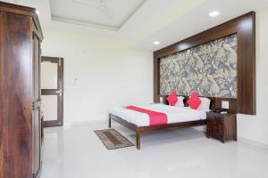 a bedroom with a bed with red pillows at OYO HOTEL SHOOLIN in Indore