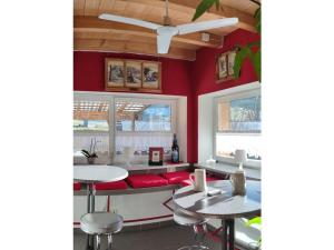 ein Restaurant mit roten Wänden, Tischen und Stühlen in der Unterkunft Bärensee Modern retreat in Marktoberdorf