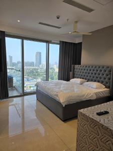 - une chambre avec un grand lit et une grande fenêtre dans l'établissement Lifestyle studios, à Gurgaon