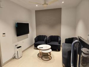 - une salle d'attente avec 2 canapés et une télévision dans l'établissement Lifestyle studios, à Gurgaon