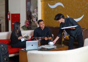 a group of people sitting around a coffee table at World Hotel Jakarta - Bandengan in Jakarta