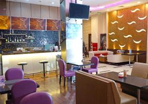 a restaurant with purple chairs and a bar at World Hotel Jakarta - Bandengan in Jakarta