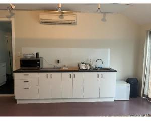 uma cozinha com armários brancos e um micro-ondas em Immaculate rooms in the Heart of the East em Sidney
