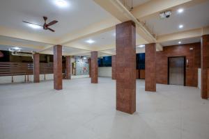 um quarto amplo com colunas e uma ventoinha de tecto em MUGUNDAN 'S SMART STAY em Coimbatore