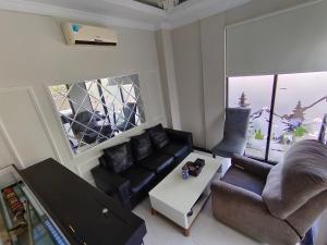 sala de estar con sofá y mesa en Pelemsewu Living Homestay Jogja, en Jarakan