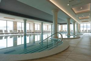 una grande piscina con sedie e tavoli di Grand Resort Pavel Banya Medical and SPA EpiCentrum a Pavel Banya
