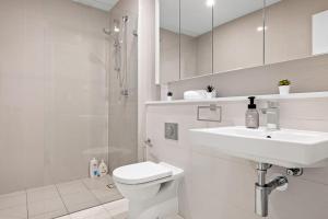シドニーにあるKing bed Apt w Sofabed in Ryde - Fast Wifiの洗面台とトイレを備えた白いバスルーム +23枚の写真