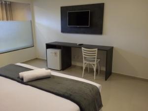 a bedroom with a desk with a computer and a chair at Scenarium Hotel in Recife