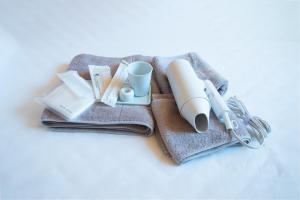a pile of towels with a coffee cup and a mug at 安全第一 客室　コンテナハウス in Nishiawakura