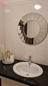 een badkamer met een wastafel en een spiegel bij Apartamento Montecarlo 1 in Sucre