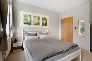 a bedroom with a bed and two paintings on the wall at Fewo zum alten Bahnhof in Dittmannsdorf