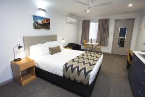 um quarto de hotel com uma cama grande e uma mesa em Altitude Motel Apartments em Toowoomba