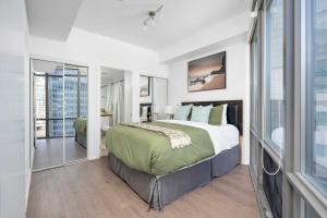 a bedroom with a large bed and a large window at Spacious 2BR+2BA w/ 4 Beds Near Yorkville! in Toronto