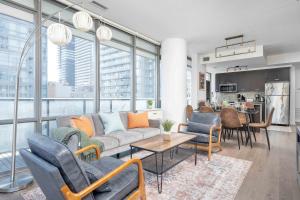 uma sala de estar com um sofá e cadeiras em Spacious 2BR+2BA w/ 4 Beds Near Yorkville! em Toronto