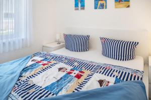 a bed with a quilt on it with two pillows at Strandnaher Bungalow in Dierhagen