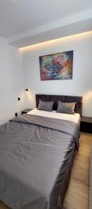 a bedroom with a large bed with a painting on the wall at Apartmán Porte in Košice