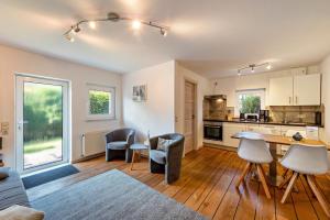 une cuisine et un salon avec une table et des chaises dans l'établissement Strandnahes Ferienhaus, à Dierhagen