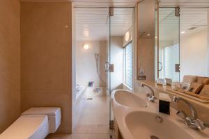 a bathroom with a tub and a sink and a shower at Hakone Hotel in Hakone