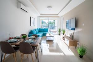 - un salon avec un canapé bleu et une table dans l'établissement Mercury Apartment, à Livadhia