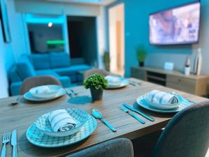 - une table en bois avec des assiettes et des couverts dans l'établissement Mercury Apartment, à Livadhia