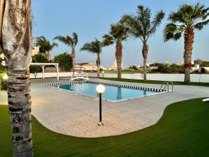 - une piscine avec des palmiers dans un complexe dans l'établissement Mercury Apartment, à Livadhia