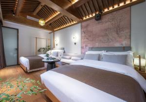 a hotel room with two beds and a couch at Xinxiang Yayuan Beijing Sihe courtyard with sky garden terrace Near Tiananmen Square Forbidden City Wangfujing Pedestrian Street and the subway in Beijing