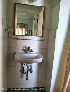 a bathroom with a sink and a mirror at Kodai Serenvilla in Kodaikānāl