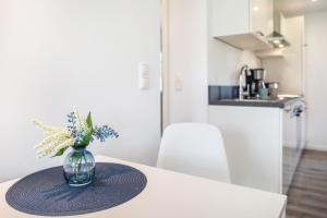 un vase de fleurs sur une table dans une cuisine dans l'établissement Strandnahe Fewo 4, à Dierhagen 15 autres photos