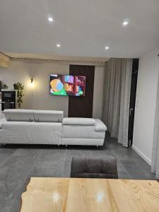 a living room with two couches and a flat screen tv at Villa de 4 chambres avec piscine privee sauna et jardin clos a Riom in Riom