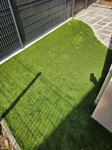 a yard with green grass next to a fence at Villa de 4 chambres avec piscine privee sauna et jardin clos a Riom in Riom
