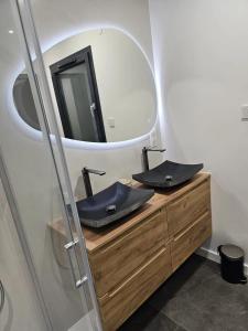 ein Badezimmer mit 2 Waschbecken und einem Spiegel in der Unterkunft Villa de 4 chambres avec piscine privee sauna et jardin clos a Riom in Riom