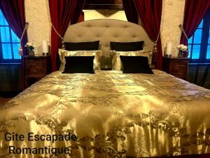 a large gold bed in a bedroom with red curtains at Escapade Romantique in Les Roches-lʼÉvêque