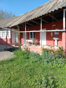 a red house with a porch and a table at Ismayilli Halal Family Guest House, Ailəvi Bag Evi, Vacation House in İsmayıllı