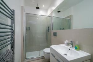 a bathroom with a shower and a sink and a toilet at GuestReady - Chic in the heart of Kensington in London