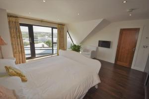 a bedroom with a large white bed and a large window at No50 Luxury 3Bed3Bath with EV Charger in Letterkenny