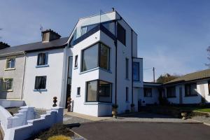 a white house with a lot of windows at No50 Luxury 3Bed3Bath with EV Charger in Letterkenny