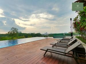 a row of chairs sitting on a wooden deck next to a river at Mosaic Southkey Johor Bahru in Johor Bahru