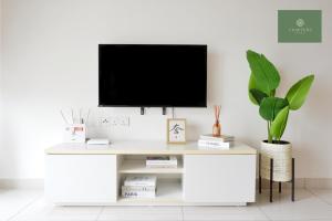 a white desk with a tv on a white wall at Mosaic Southkey Johor Bahru in Johor Bahru