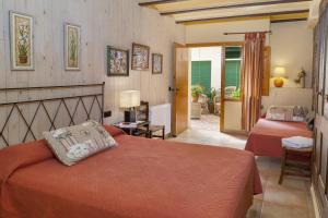 a bedroom with two beds and a door to a patio at Casa Rural Can Coll in Garriguella
