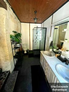 La salle de bains est pourvue d'un lavabo et de toilettes. dans l'établissement Escapade Romantique, à Les Roches-lʼÉvêque