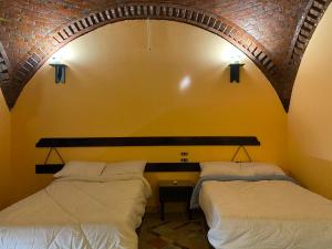 2 camas en una habitación con una pared de ladrillo en Oasis inn House, en Mandīshah