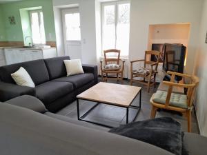 - un salon avec un canapé et des chaises dans l'établissement Le gîte du Haut-Breuil proche de Beauval châteaux de la Loire, à Vicq-sur-Nahon