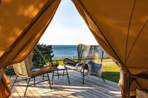 eine Terrasse mit zwei Stühlen und einem Tisch mit einem Vogel darauf in der Unterkunft Gökaskratts Camping in Hovmantorp