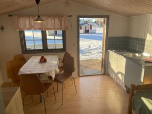 eine Küche und ein Esszimmer mit einem Tisch und Stühlen in der Unterkunft Gökaskratts Camping in Hovmantorp