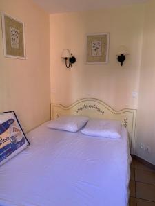a bed in a bedroom with two pillows on it at Appartement région de St-Tropez in Grimaud +10 photos