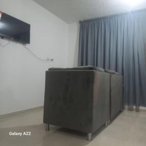 a tv sitting in a room with a curtain at APARTAMENTO 3 HABITACIONES 6 PERSONAS SIN AIRE ACONDICIONADO - ventilador MAS DE 3 NOCHES in Valledupar