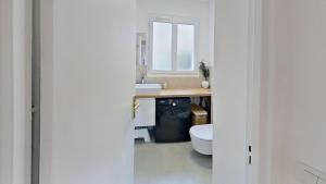 ein weißes Bad mit einem Waschbecken und einem WC in der Unterkunft Beautiful 2 Bedroom apartment in a quiet residence in Garches